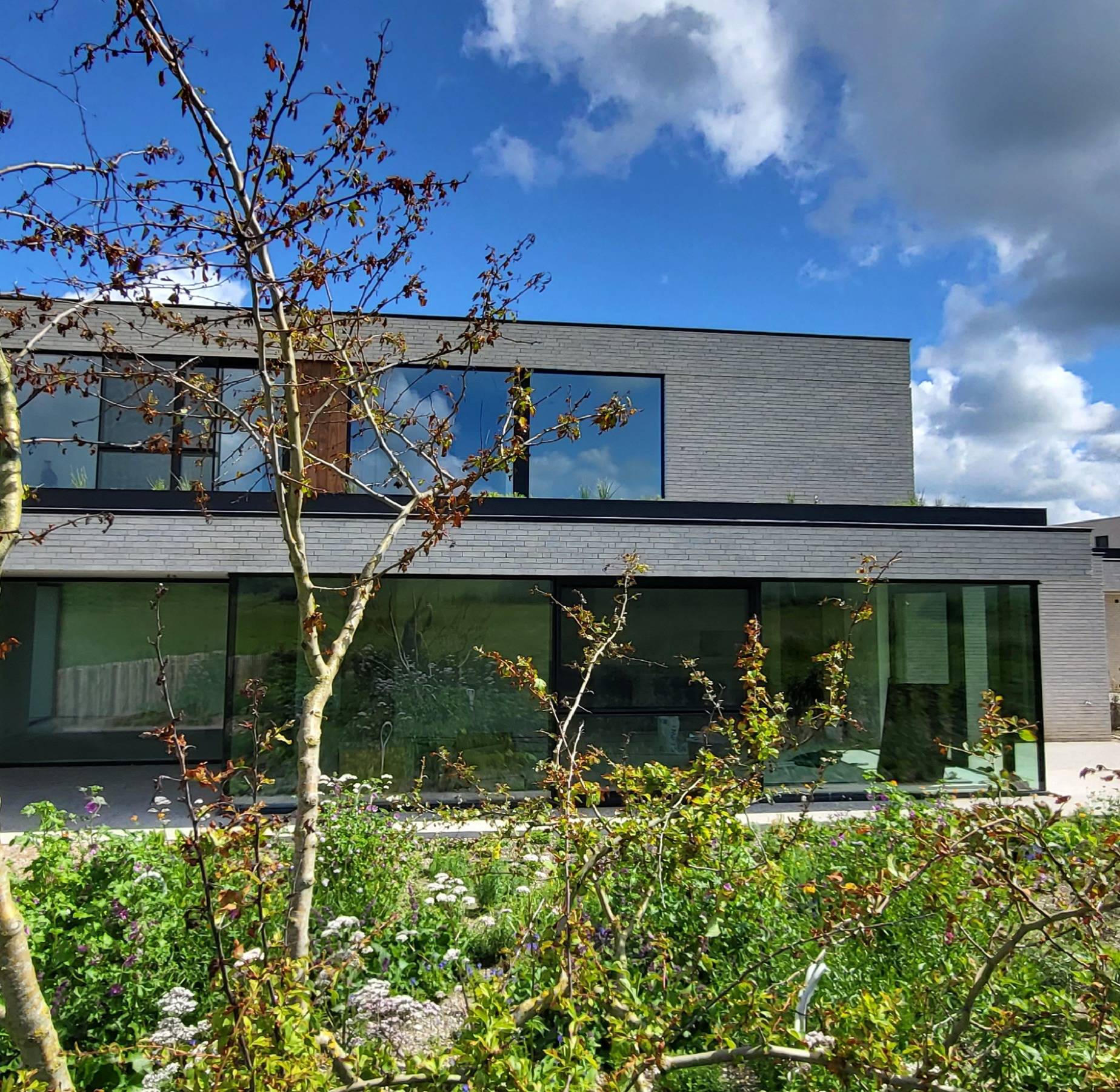 Moderne villa met grote glaspartijen in zwarte aluminium profielen, uitgevoerd door Declerck Schrijnwerk