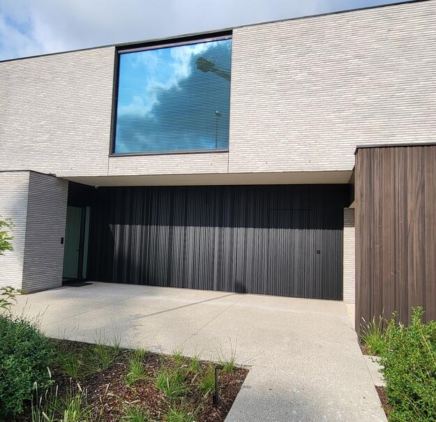 Alleenstaande woning met geïntegreerde dokterspraktijk, voorzien van aluminium ramen en deuren door Declerck Schrijnwerk