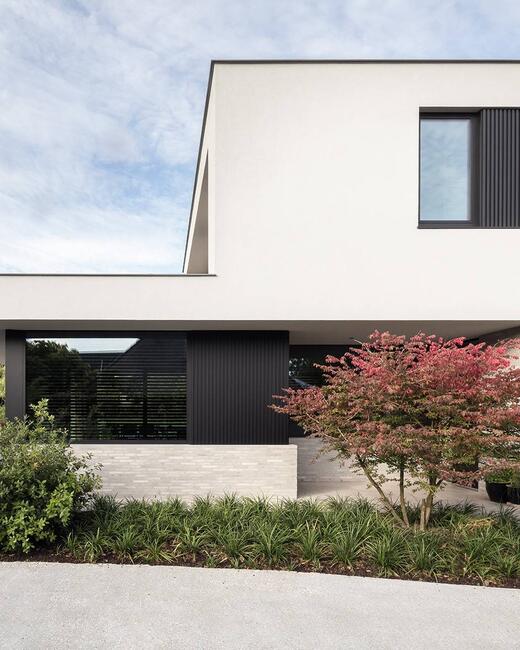 Villa met witte baksteen, zwarte aluminium ramen en mato gevelbekleding – tijdloze architectuur met moderne accenten